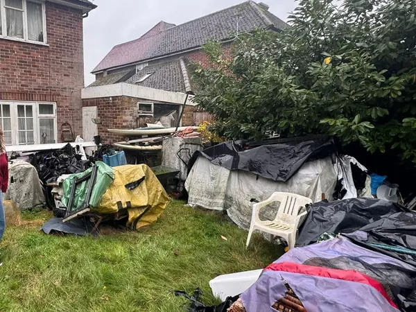 Garage and garden piled with contents before clearance