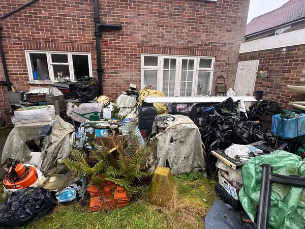 Garage and garden piled with contents before clearance