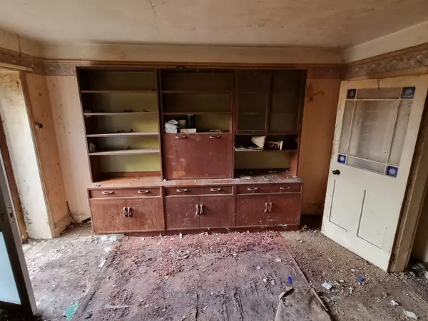 The same room emptied, only the fireplace left